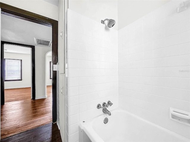 bathroom with tiled shower / bath and hardwood / wood-style floors