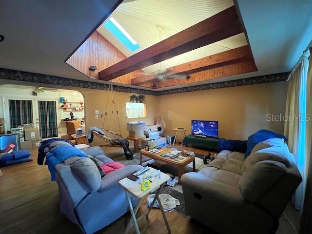 interior space featuring beamed ceiling, ceiling fan, and dark hardwood / wood-style flooring