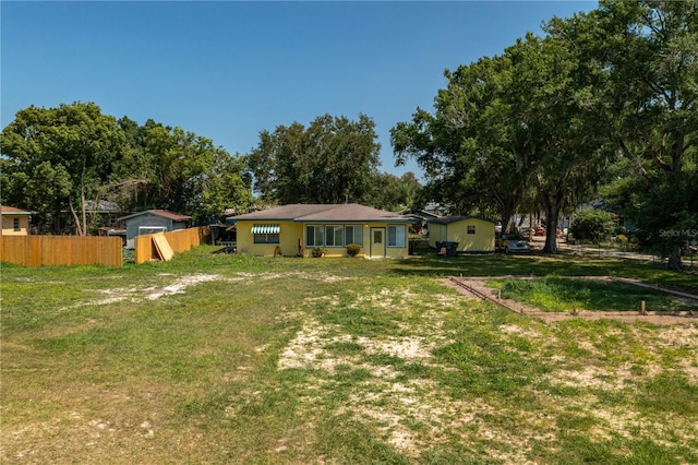 view of front of property featuring a front lawn and a shed