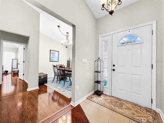 foyer with tile flooring, a healthy amount of sunlight, and an inviting chandelier