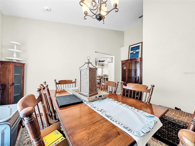 dining area featuring a chandelier and a textured ceiling