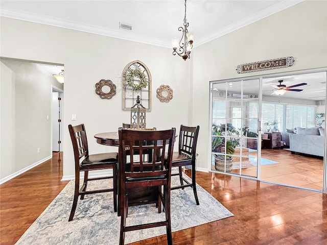 dining room with ceiling fan with notable chandelier, hardwood / wood-style floors, and crown molding