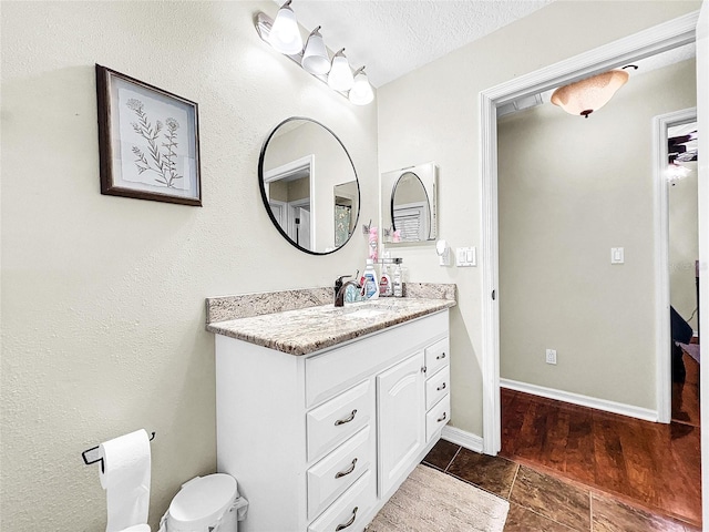 bathroom featuring oversized vanity, toilet, tile floors, and a textured ceiling