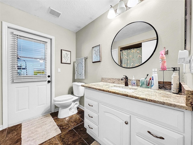 bathroom featuring toilet, tile floors, vanity, and a textured ceiling