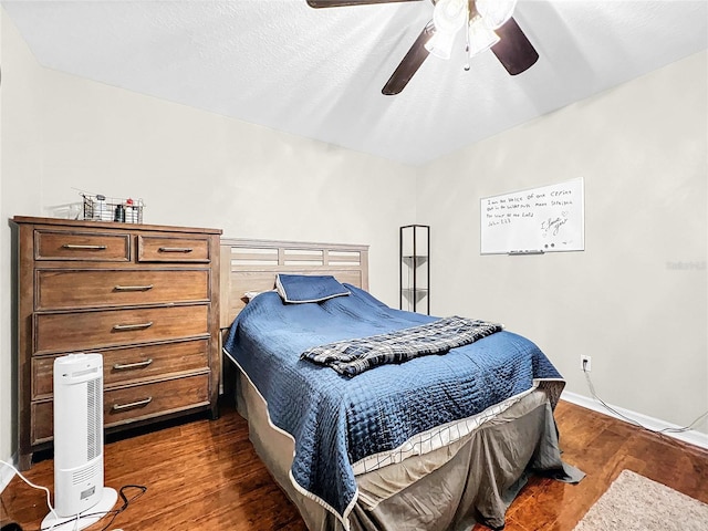 bedroom with dark hardwood / wood-style flooring and ceiling fan