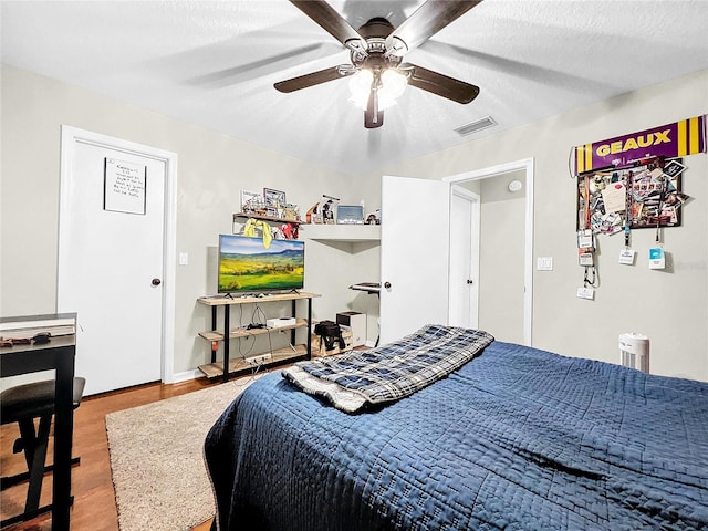 bedroom with wood-type flooring, a textured ceiling, and ceiling fan