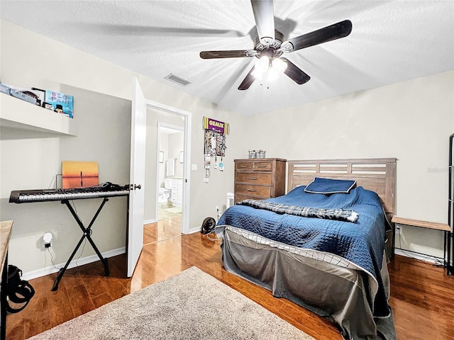 bedroom featuring wood-type flooring, ceiling fan, and a textured ceiling