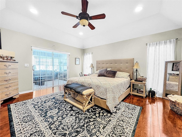 bedroom featuring a raised ceiling, ceiling fan, access to exterior, and dark wood-type flooring