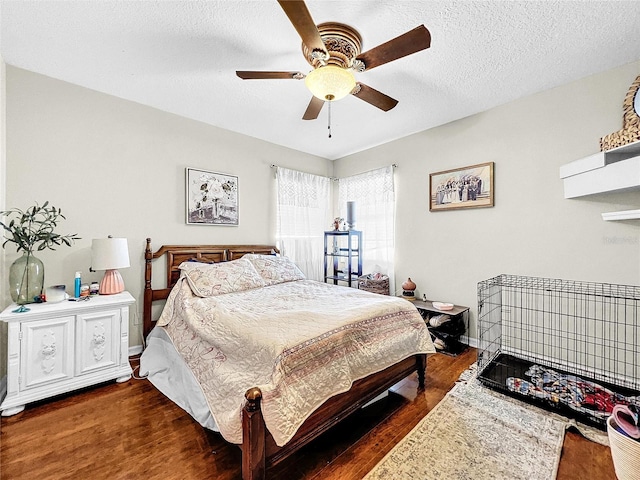 bedroom with ceiling fan, dark hardwood / wood-style flooring, and a textured ceiling