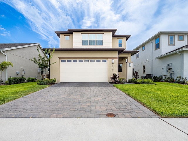 view of front of property with central AC, a garage, and a front lawn