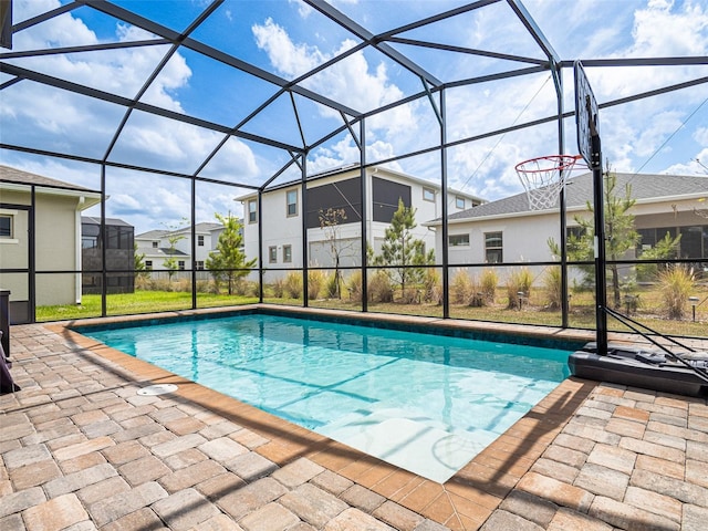 view of swimming pool featuring a lanai and a patio area