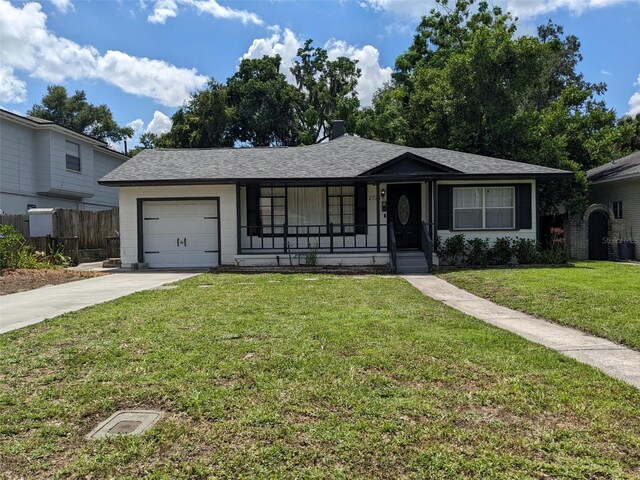 single story home featuring a porch, a garage, and a front lawn