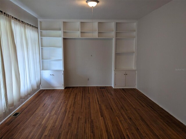 unfurnished bedroom featuring dark hardwood / wood-style floors and a closet