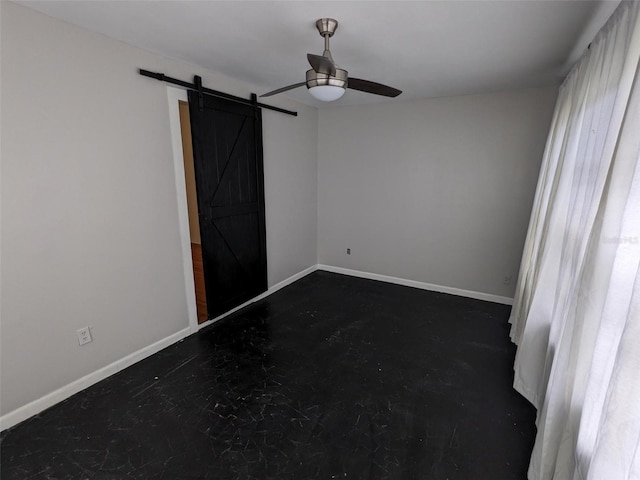 unfurnished room featuring a barn door and ceiling fan