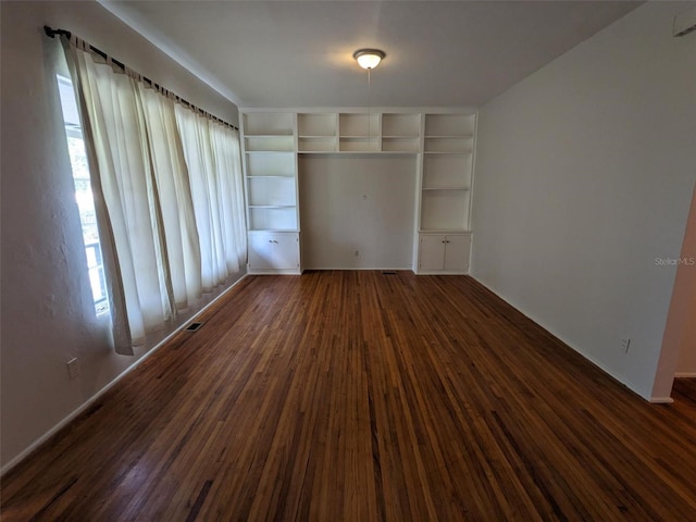 unfurnished bedroom featuring dark hardwood / wood-style flooring and a closet