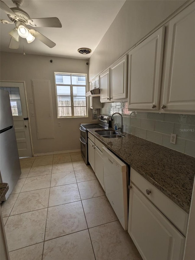 kitchen with tasteful backsplash, appliances with stainless steel finishes, sink, and white cabinets