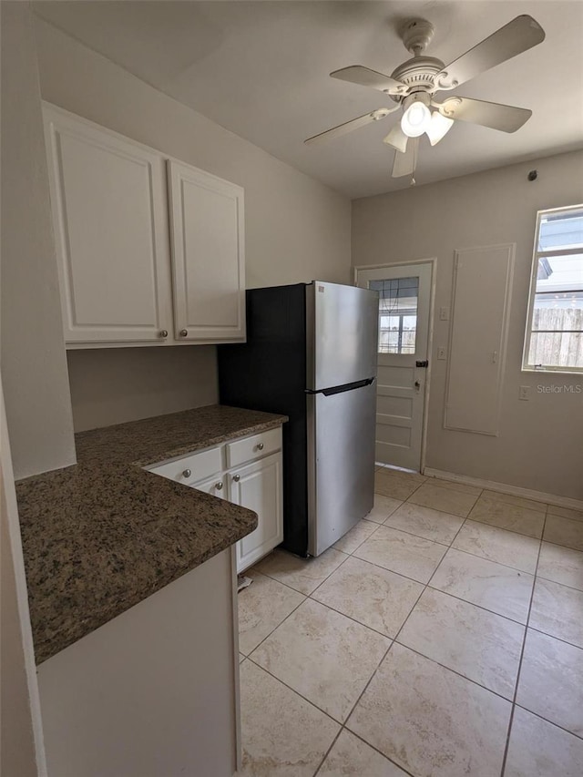 kitchen featuring light tile patterned flooring, ceiling fan, white cabinets, and stainless steel refrigerator