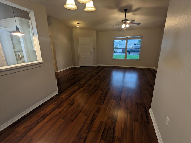 unfurnished room featuring dark wood-type flooring and ceiling fan