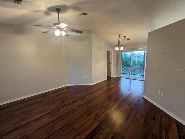 empty room featuring dark wood-type flooring, lofted ceiling, ceiling fan with notable chandelier, and a textured ceiling