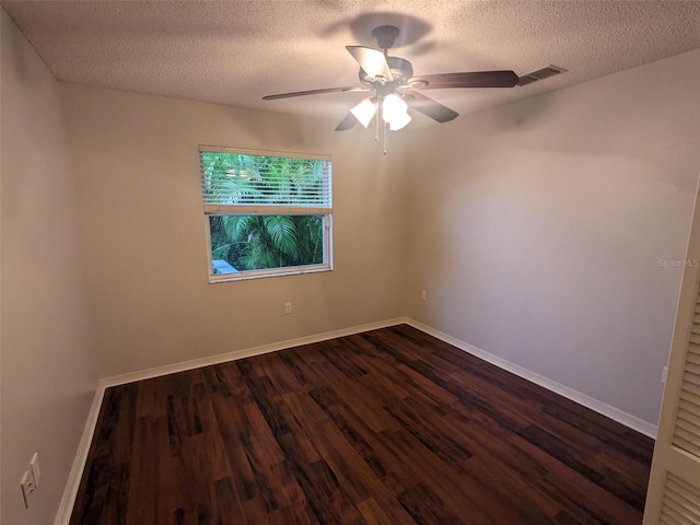 empty room featuring ceiling fan, a textured ceiling, and dark hardwood / wood-style flooring