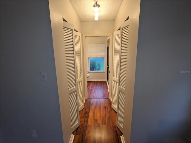 corridor featuring dark hardwood / wood-style floors and a textured ceiling