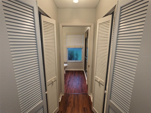 hallway featuring dark hardwood / wood-style floors and a textured ceiling