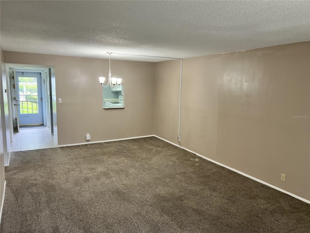 carpeted empty room with an inviting chandelier and a textured ceiling