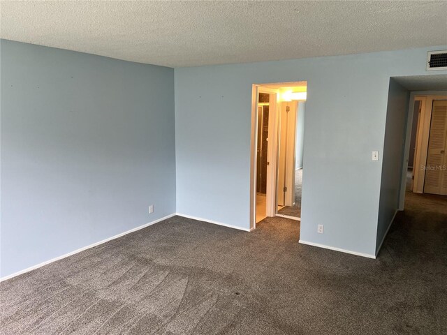 carpeted empty room featuring a textured ceiling