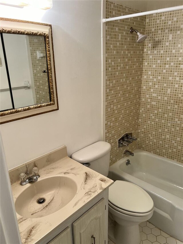 full bathroom featuring vanity, tiled shower / bath combo, toilet, and tile patterned floors