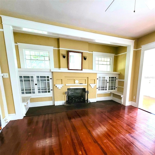 unfurnished living room with wood finished floors and a fireplace with flush hearth