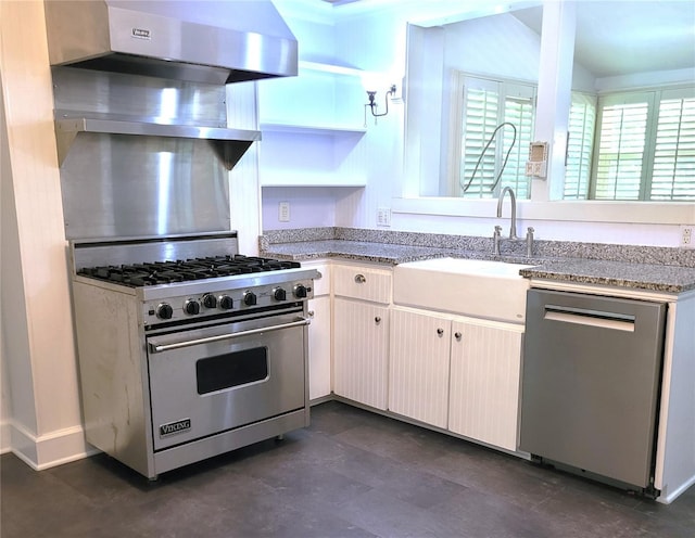 kitchen featuring white cabinets, appliances with stainless steel finishes, light stone counters, and a sink