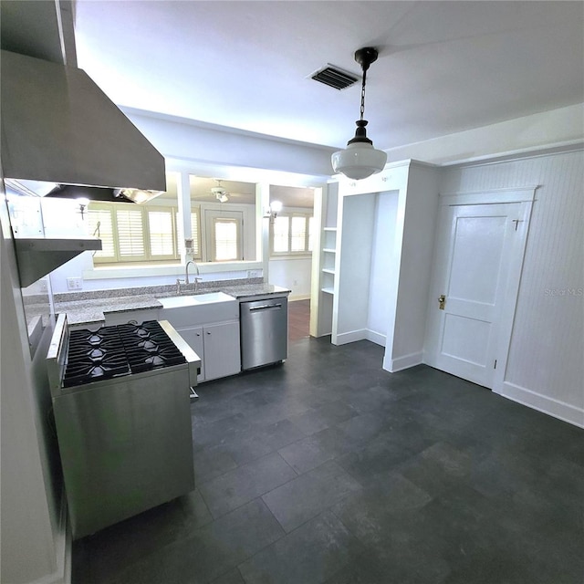 kitchen featuring light countertops, appliances with stainless steel finishes, white cabinetry, a sink, and island range hood