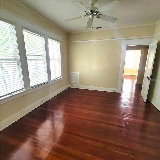 unfurnished room featuring plenty of natural light, visible vents, and dark wood finished floors