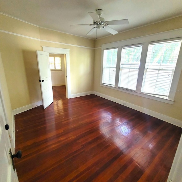 spare room featuring ceiling fan, dark wood-type flooring, and baseboards