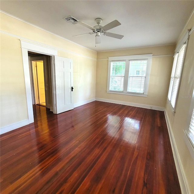 unfurnished room featuring visible vents, baseboards, dark wood finished floors, and a ceiling fan