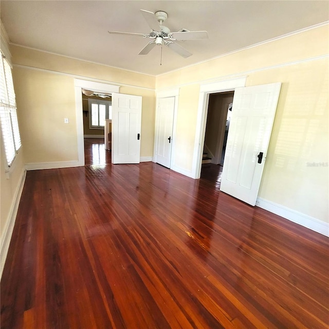 unfurnished bedroom featuring dark wood-style floors, a ceiling fan, and baseboards