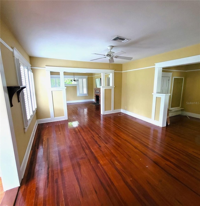 empty room featuring dark wood-type flooring, a fireplace, and visible vents