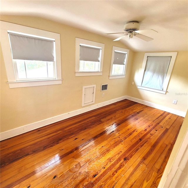 spare room featuring a ceiling fan, baseboards, vaulted ceiling, and hardwood / wood-style floors