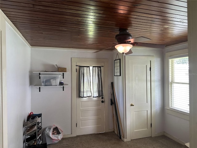 doorway to outside featuring a healthy amount of sunlight, wood ceiling, and carpet floors