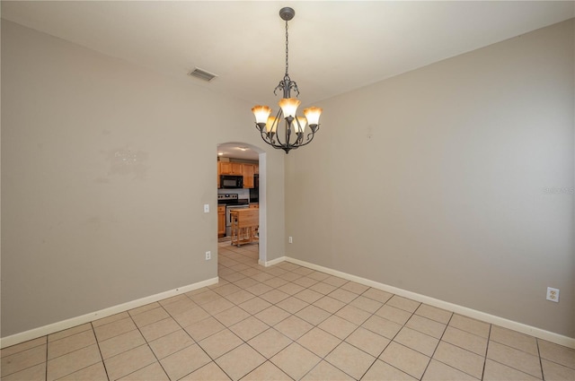 empty room featuring light tile patterned floors and a notable chandelier