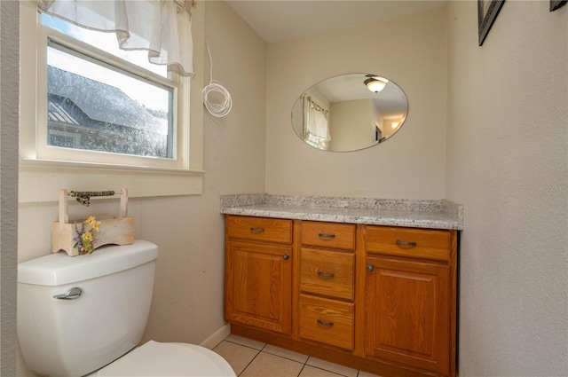 bathroom with toilet, vanity, and tile patterned flooring