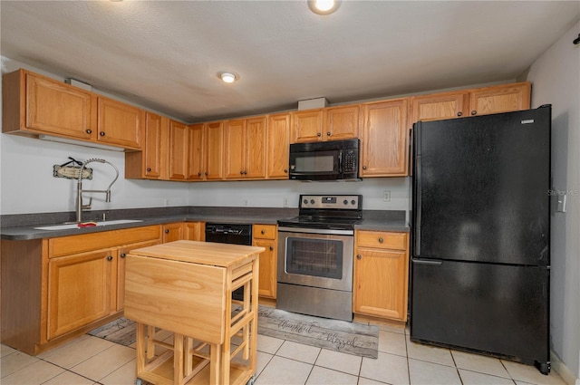 kitchen featuring black appliances, light tile patterned floors, and sink