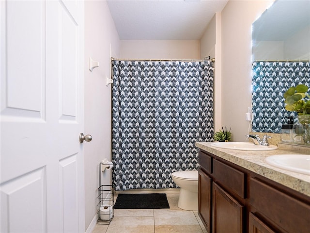 bathroom featuring tile patterned floors, double sink vanity, and toilet