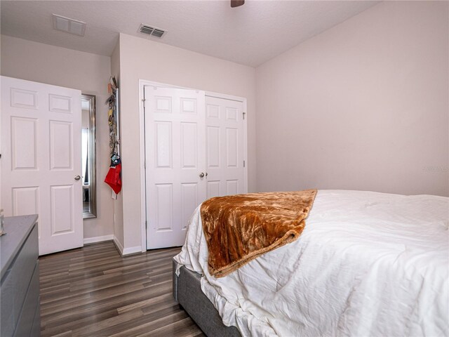 bedroom with dark hardwood / wood-style floors and a closet