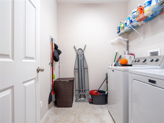 clothes washing area with light tile patterned flooring and washing machine and dryer