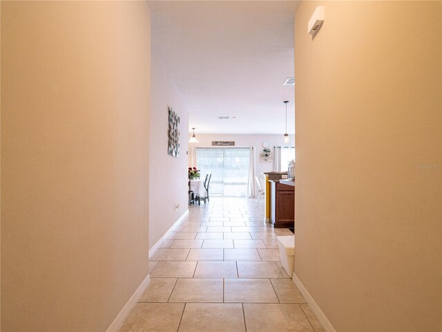 hall with light tile patterned floors