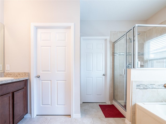 bathroom featuring independent shower and bath, tile patterned floors, and vanity