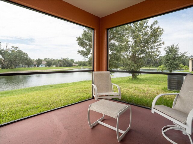 sunroom featuring a water view