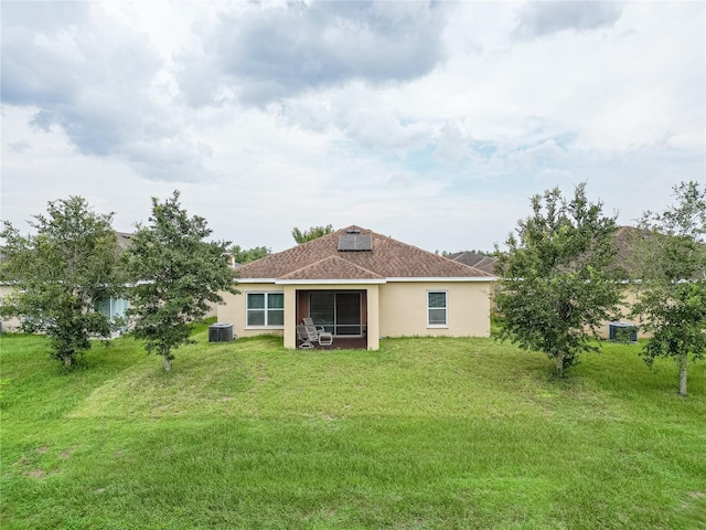 back of property featuring a yard and central AC