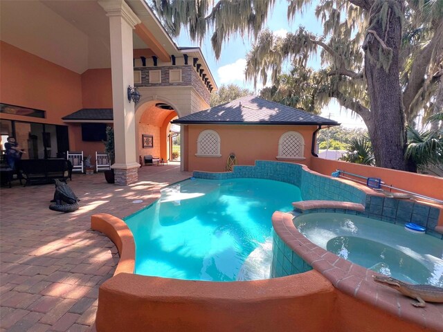 view of swimming pool with a patio and an in ground hot tub